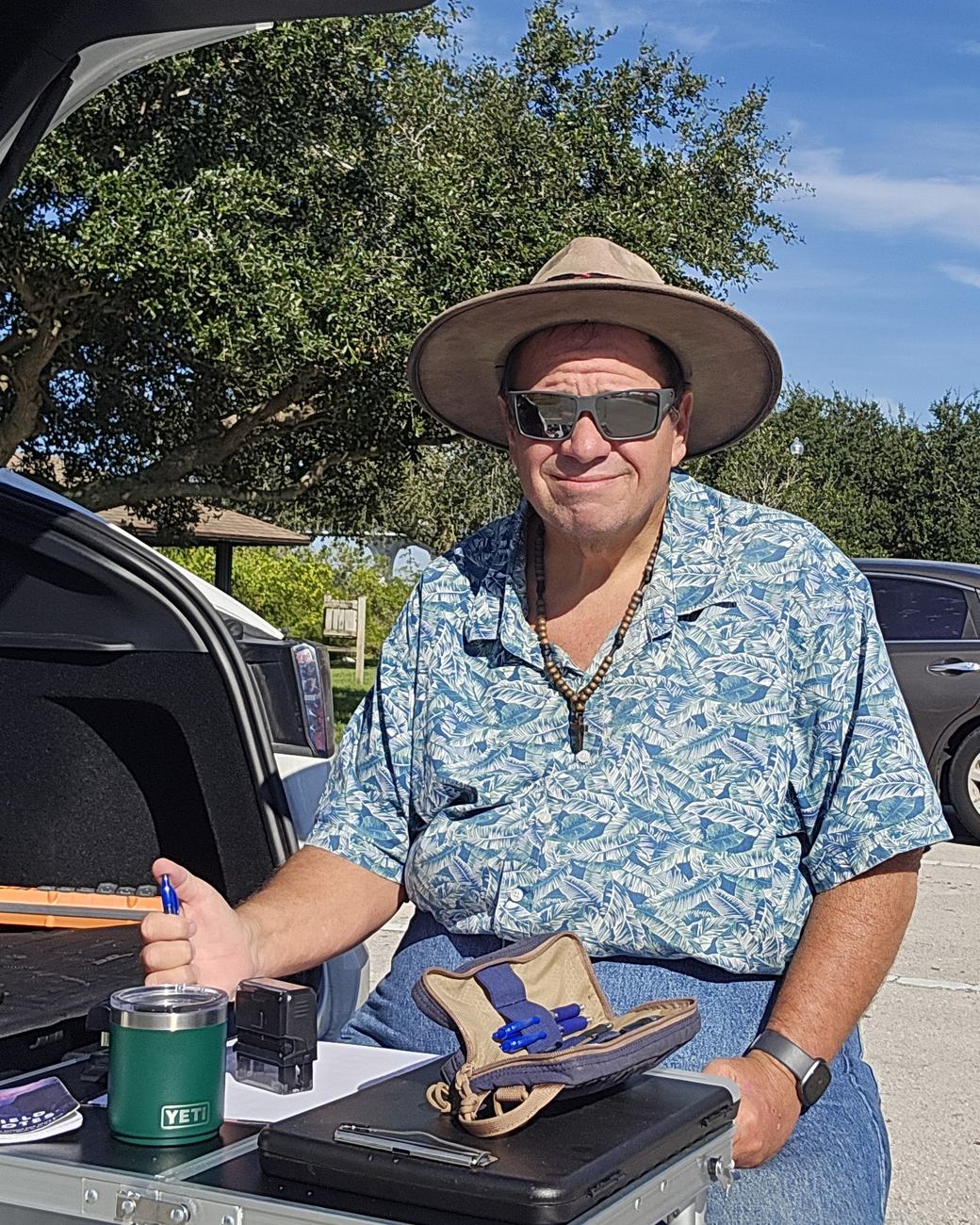 Jonathan Rexford, mobile notary, in his hat and sunglasses beside his Tesla in Vero Beach